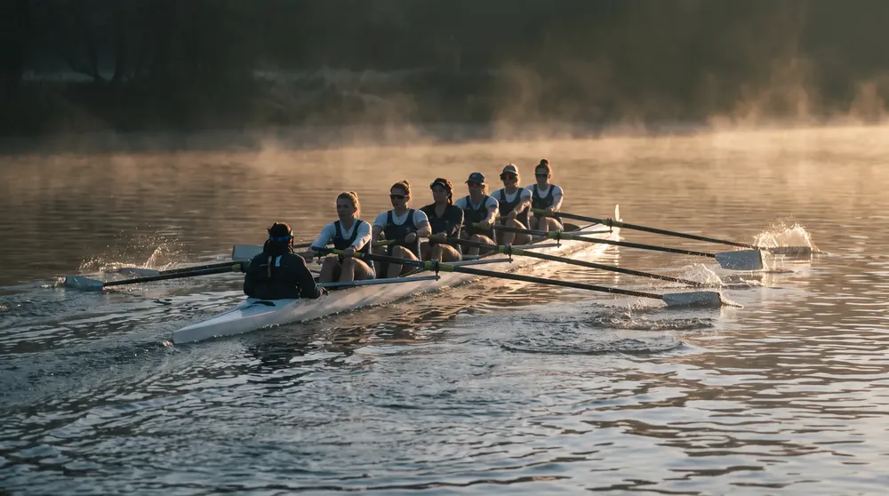 A coxed eight training on a misty English river at dawn